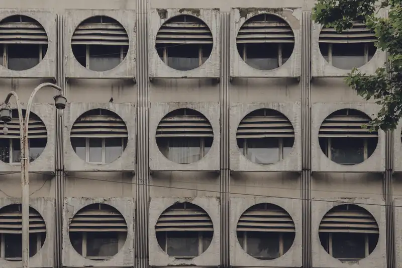 A modernist façade in Chișinău with round windows repeated in a grid.