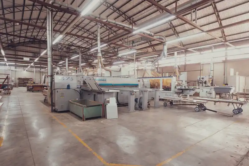 A furniture production hall with panel saws and edge banders, no people.